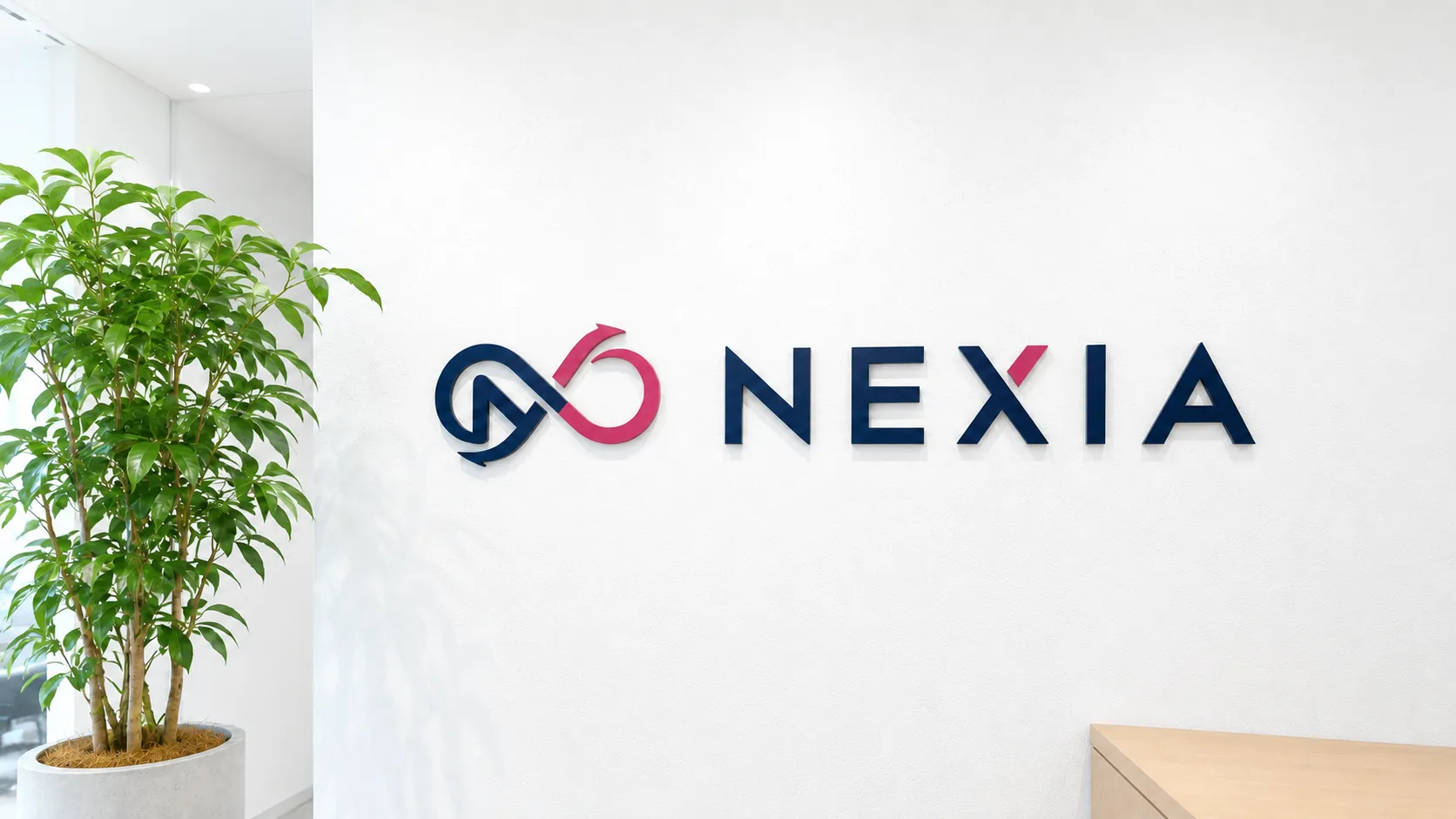 オフィスの壁に掲げた株式会社NEXIAのロゴサイン